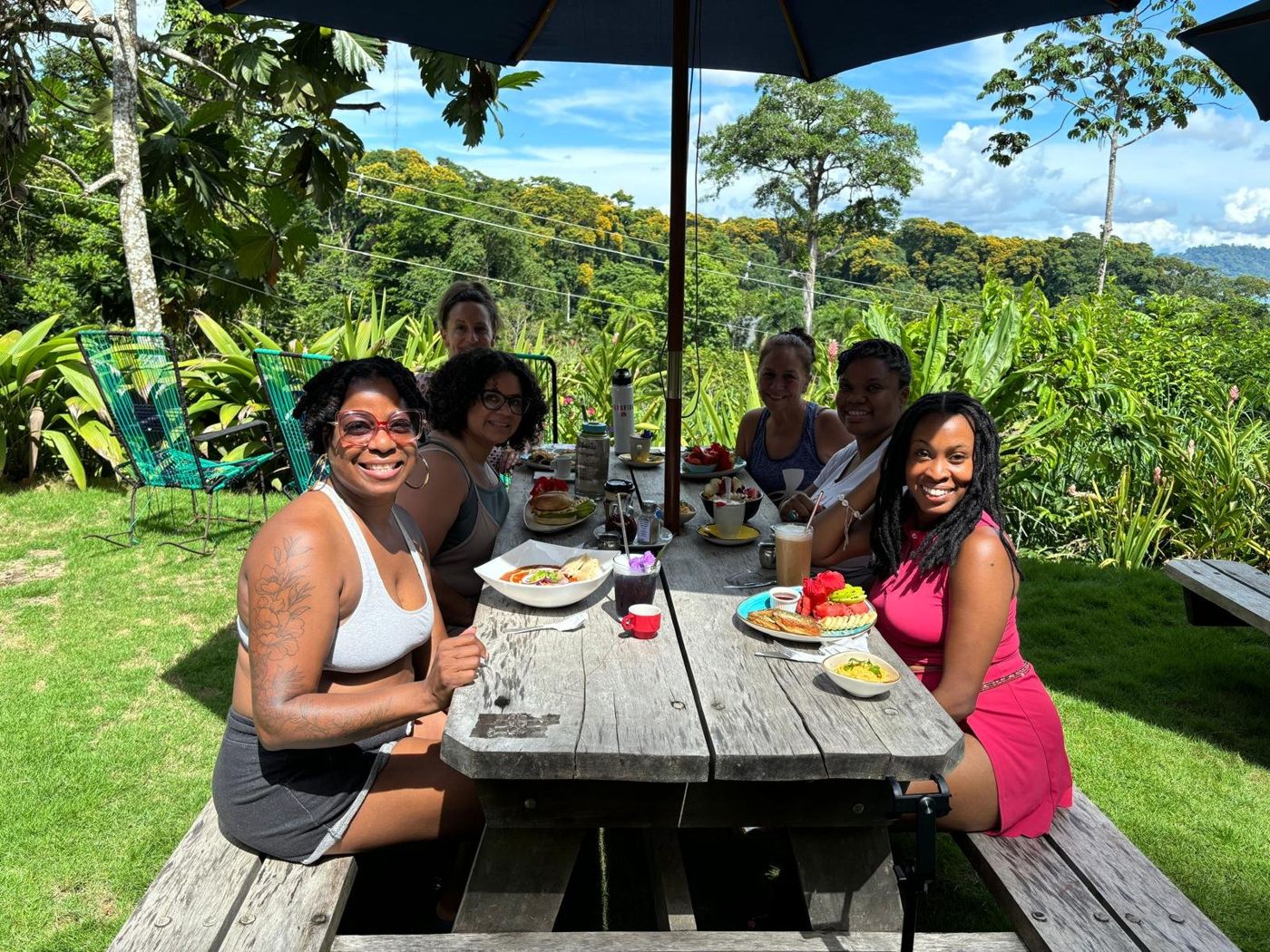 Retreat guests sharing a meal at a garden table in the hills