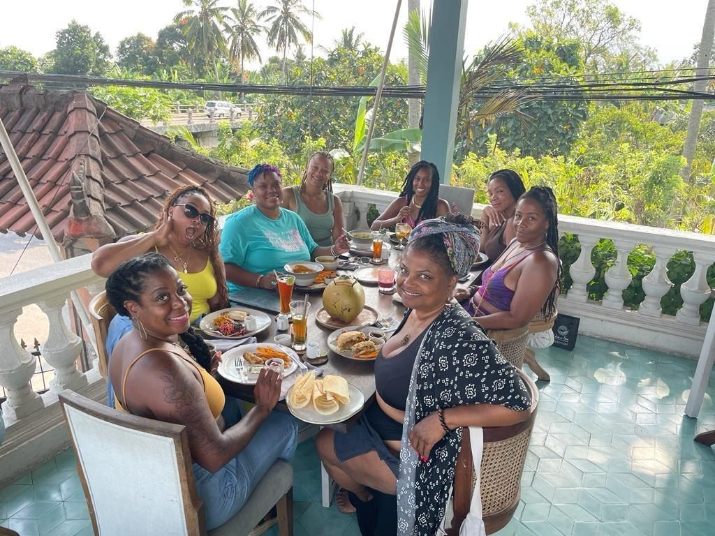 A shared lunch on a terrace with a view of palms
