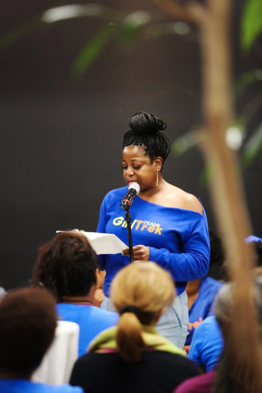 Terry speaking at the microphone to a room of women